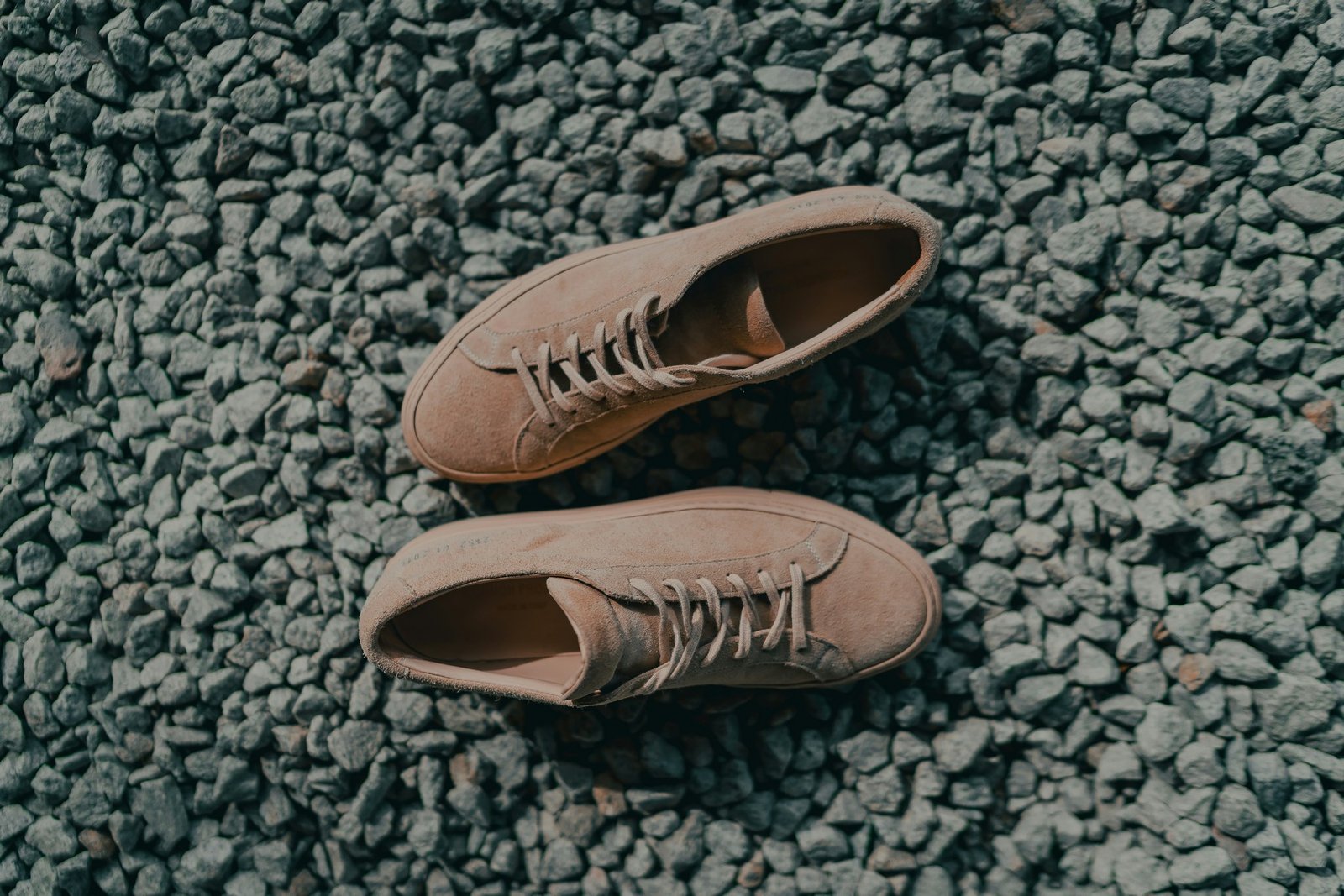 Helle Wildlederschuhe in Beige auf einem weißen Untergrund