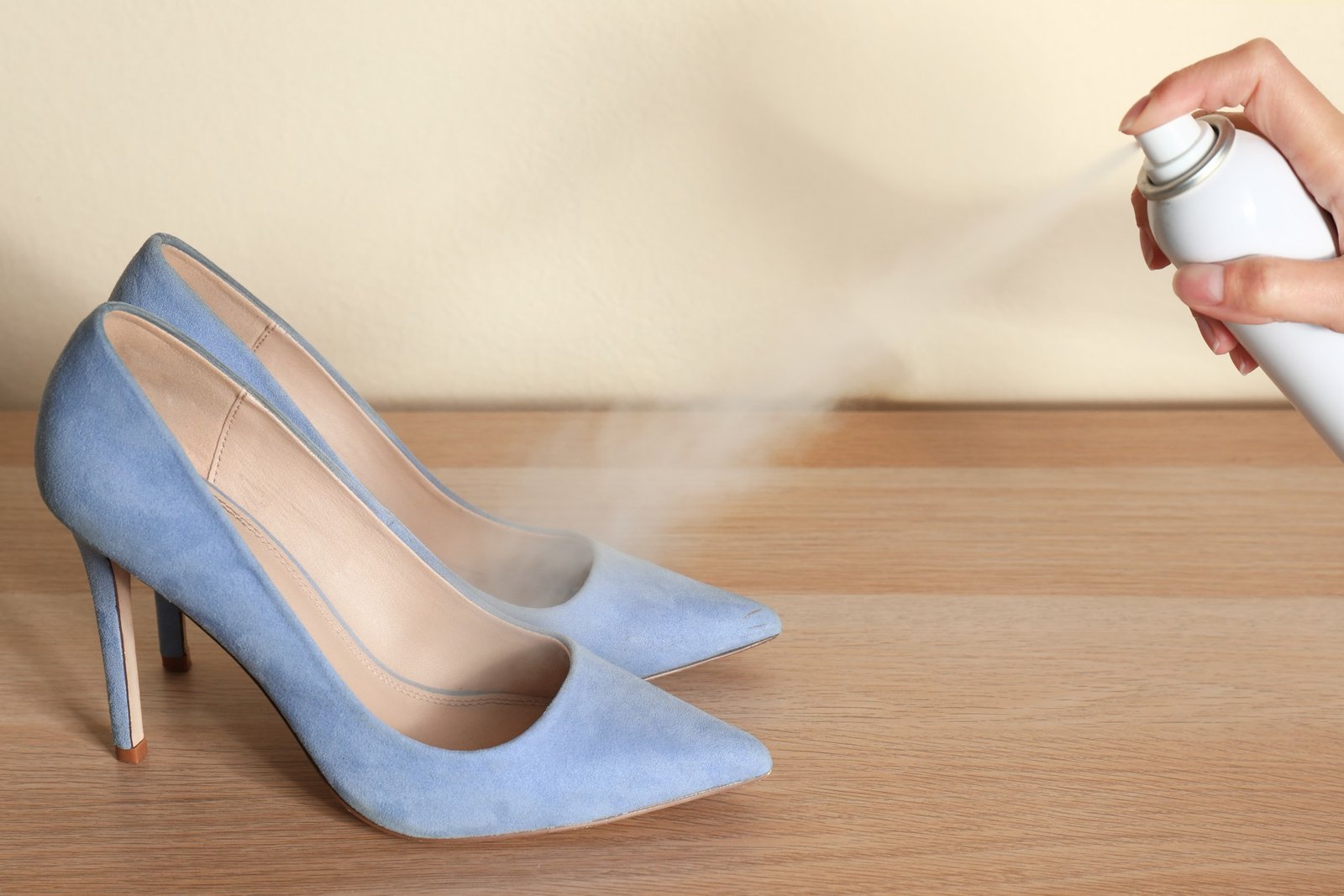 Schutzspray wird auf einen Schuh aufgesprüht