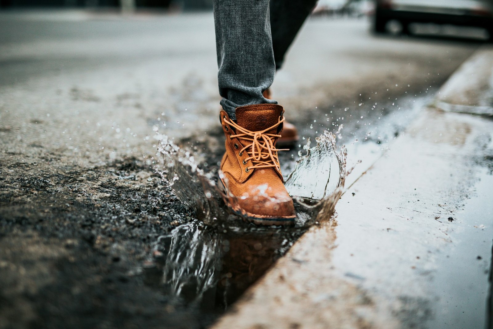 Nasse Wildlederschuhe nach einem Regenschauer auf feuchtem Boden