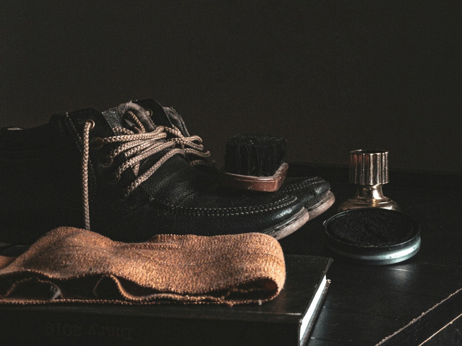 Schuhe mit herausgezogenen Schnürsenkeln neben Pflegeutensilien